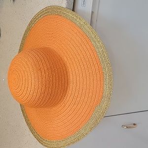 Orange straw summer hat with  gold trim.
